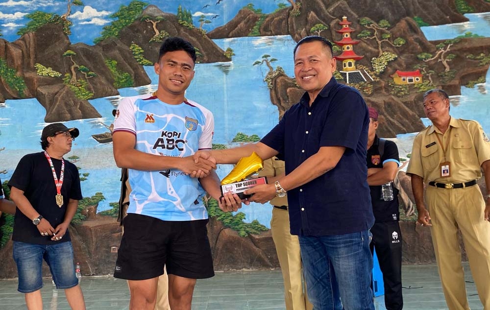 Ketua KONI Banyuwangi Ahmad Khoirullah menyerahkan piala kepada Alfian Alfarid  sebagai top skor Liga 4 Jatim di AIL Blimbingsari, Senin (24/2).