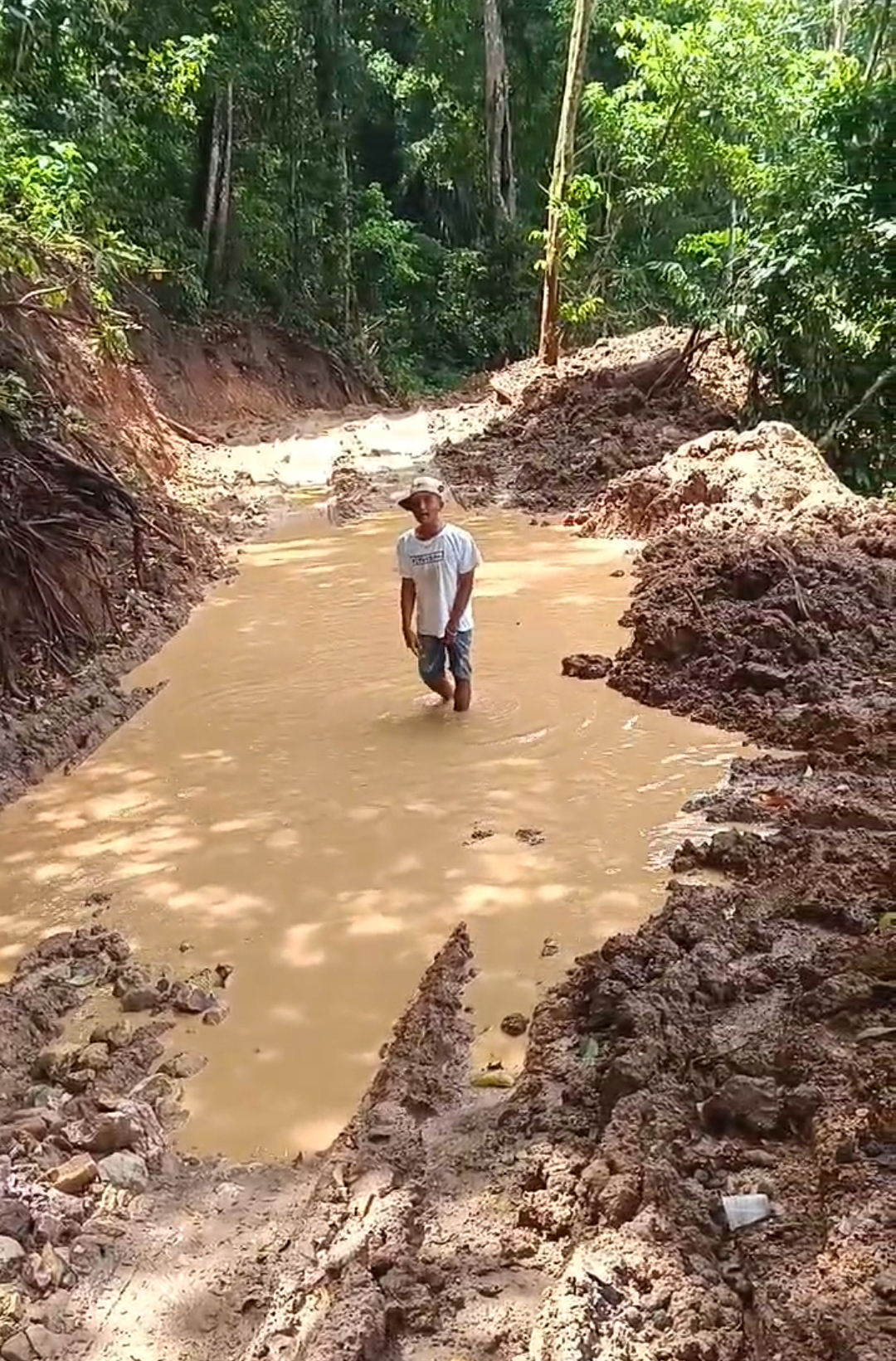 JADI KOLAM: Warga melintas di salah satu titik jalan paling rusak di daerah hutan Dusun Sukamade, Desa Sarongan, Kecamatan Pesanggaran Senin (24/2).
