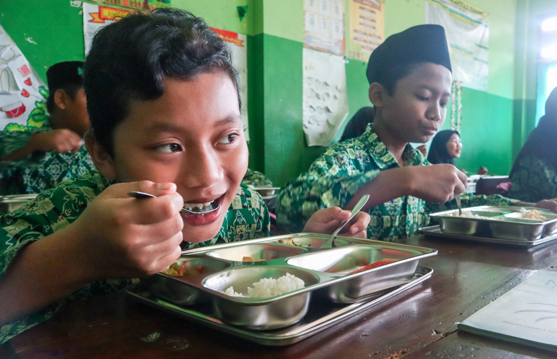 Sejumlah siswa Madrasah Ibtidaiyah (MI) Salafiyah, Kecamatan Sempu menikmati makan bergizi gratis yang dikirim dari dapur umum Sempu, Rabu (26/2).