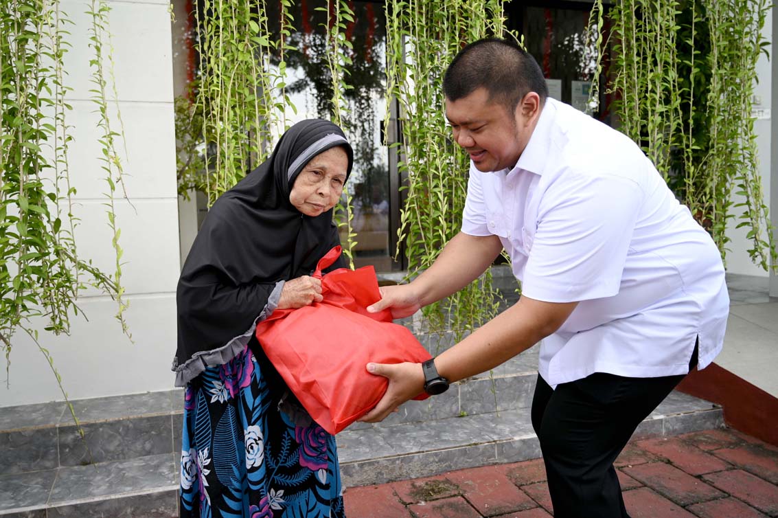 WARGA KURANG MAMPU: Ketua Hipmi Banyuwangi Ferdy Elfian ikut menyerahkan sembako kepada warga Penataban, Giri.