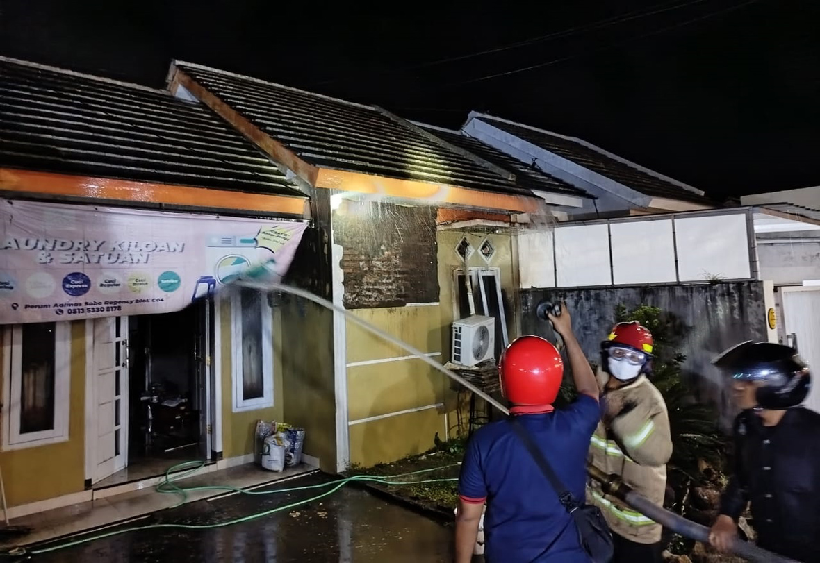 HANGUS: Petugas Damkarmat memadamkan api yang membakar rumah Diah Safitri Megawati di Perumahan Adimas Sobo Regency, Minggu dini hari (2/3).