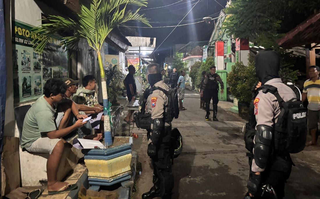 SIAGA: Aparat Polresta Banyuwangi bersama warga bersiaga di poskamling di Kelurahan Tumenggungan, Kecamatan Banyuwangi, Jumat dini hari (7/3).