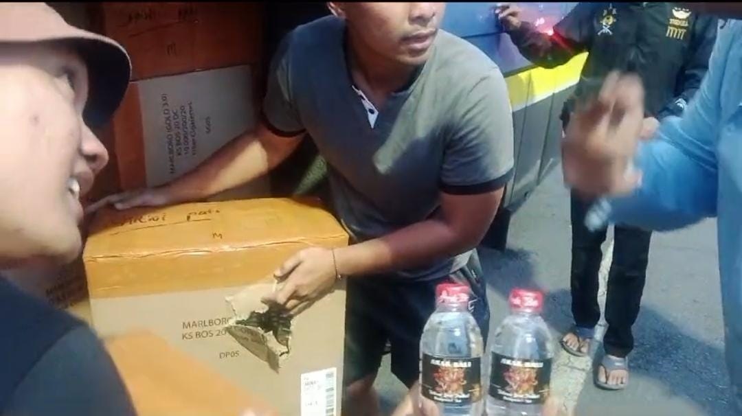 Anggota Satpolairud mengamankan botol arak dari kapal penumpang yang bersandar di Dermaga ASDP Ketapang, Banyuwangi, Jumat (7/3/2025). (Humas Polresta Banyuwangi)