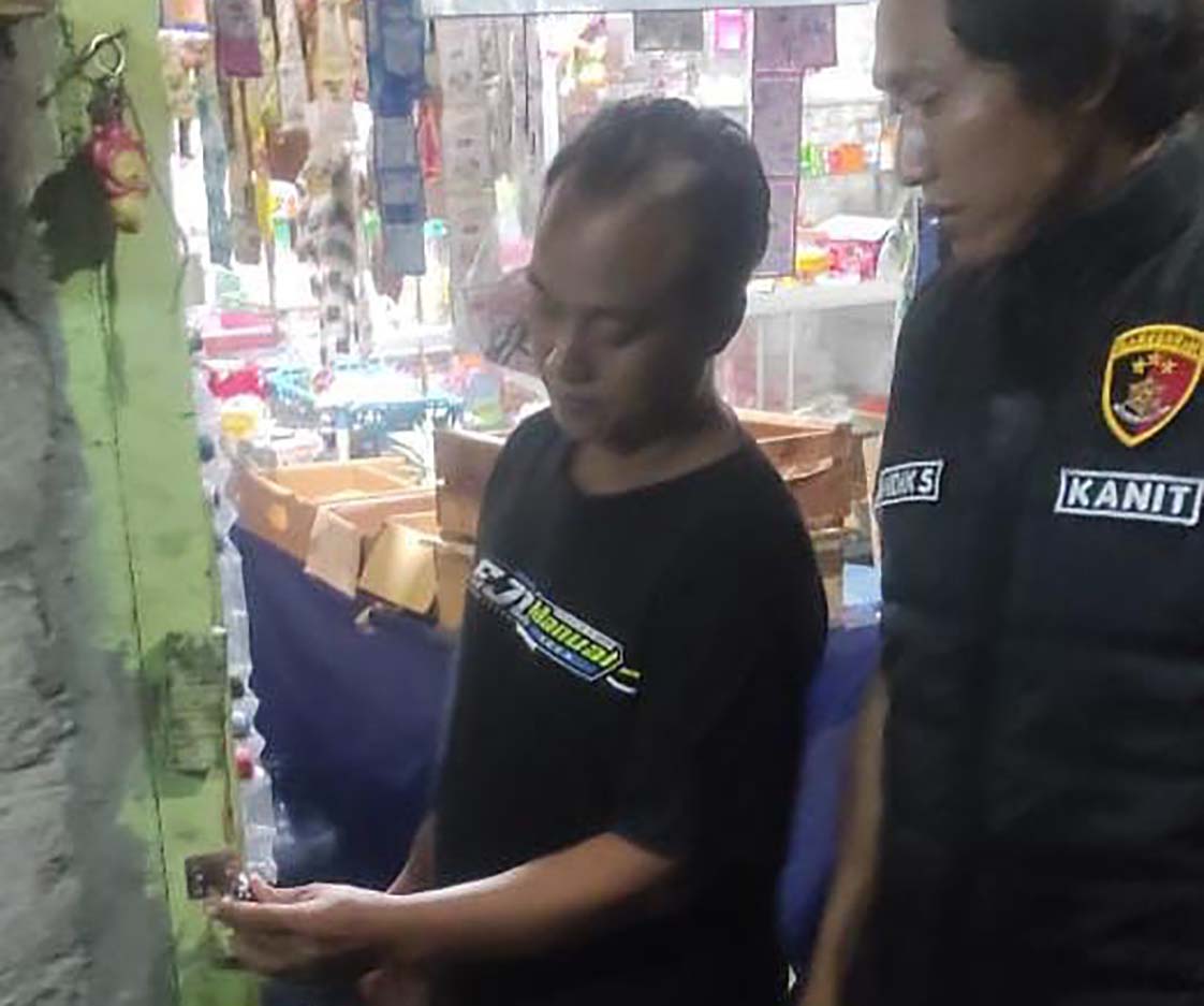 OLAH TKP: Kanit Reskrim Polsek Purwoharjo Aipda Andik Suwandana memeriksa pintu di toko klontong milik Juni di Dusun Gumukrejo, Desa/Kecamatan Purwoharjo, Kamis (6/3) dini hari.