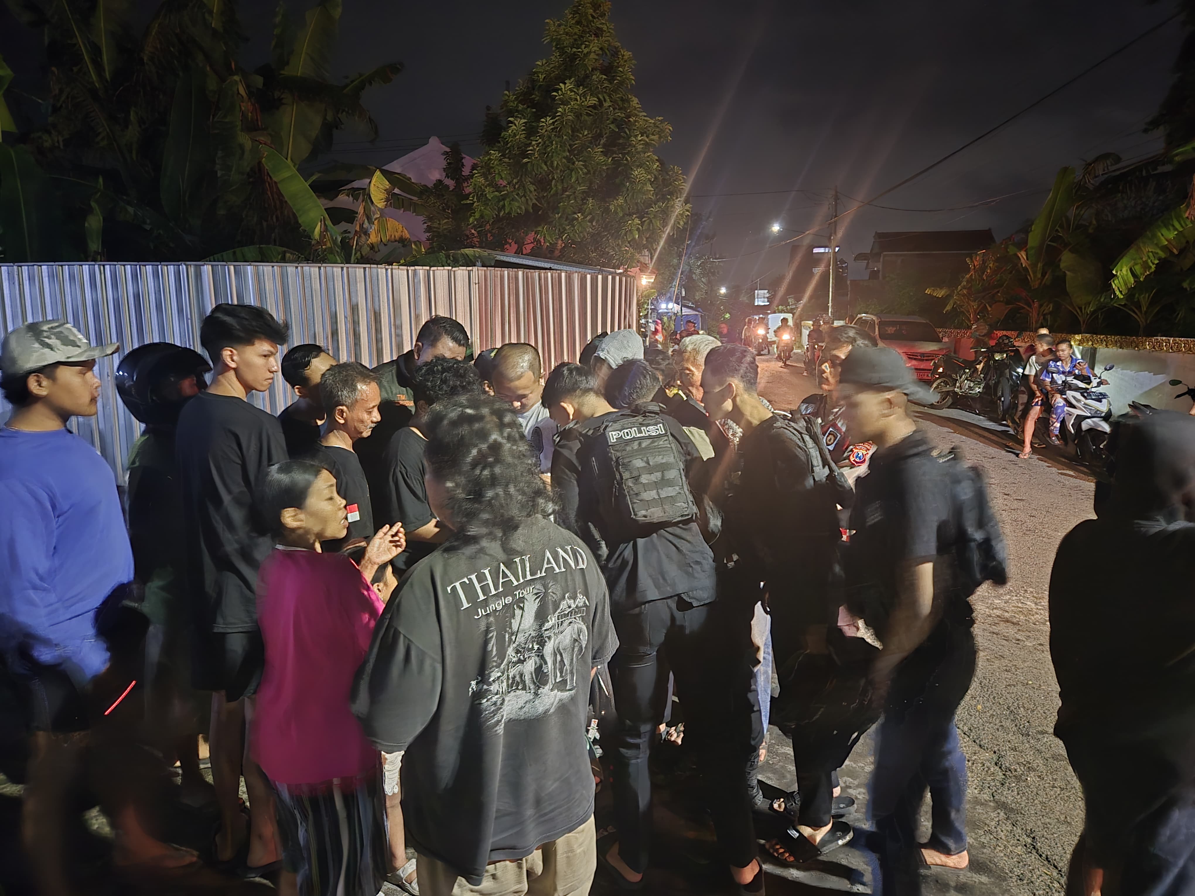 RAMAI: Sejumah warga dan aparat kepolisian berkumpul di TKP Pembacokan yang berada Lingkungan Cungking, Kelurahan Mojopanggung, Kecamatan Giri, Minggu (9/3)