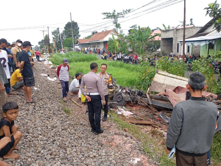 Petugas kepolisian berjaga di dekat truk pupuk yang ringsek usai tersambar KA Kertanegara di Kabupaten Kediri, Jawa Timur, Senin (10/3).