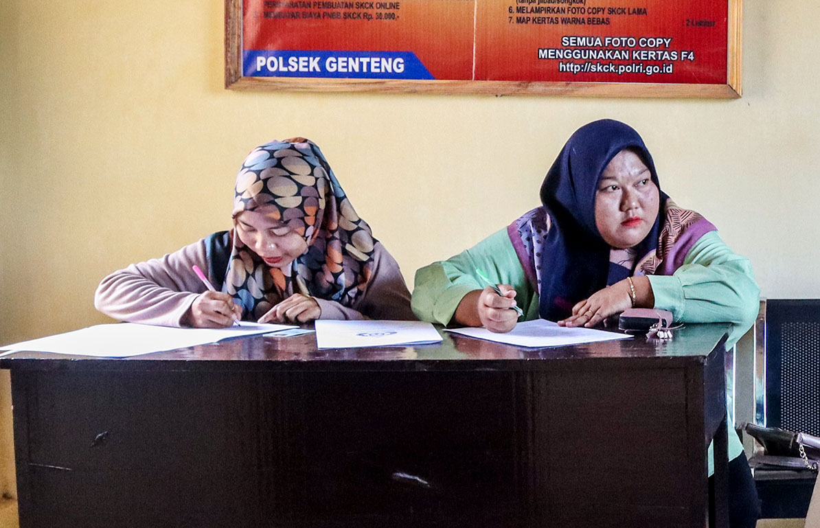 Dua emak-emak mengisi form SKCK di Mapolsek Genteng sebagai syarat melamar di dapur MBG. (Salis Ali/Radar Genteng)