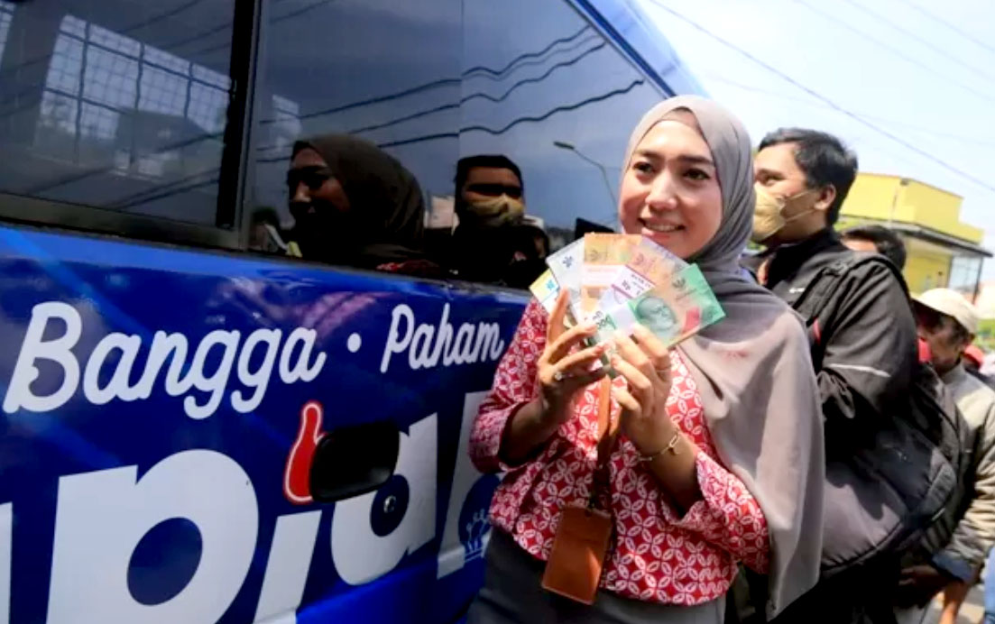 Warga menukar pecahan uang baru di mobil kas BI yang mangkal di depan Alun-alun Kota Madiun. Penukaran uang hanya dilayani jika sudah mendaftar online. (Bagas Bimantara/ Radar Madiun)