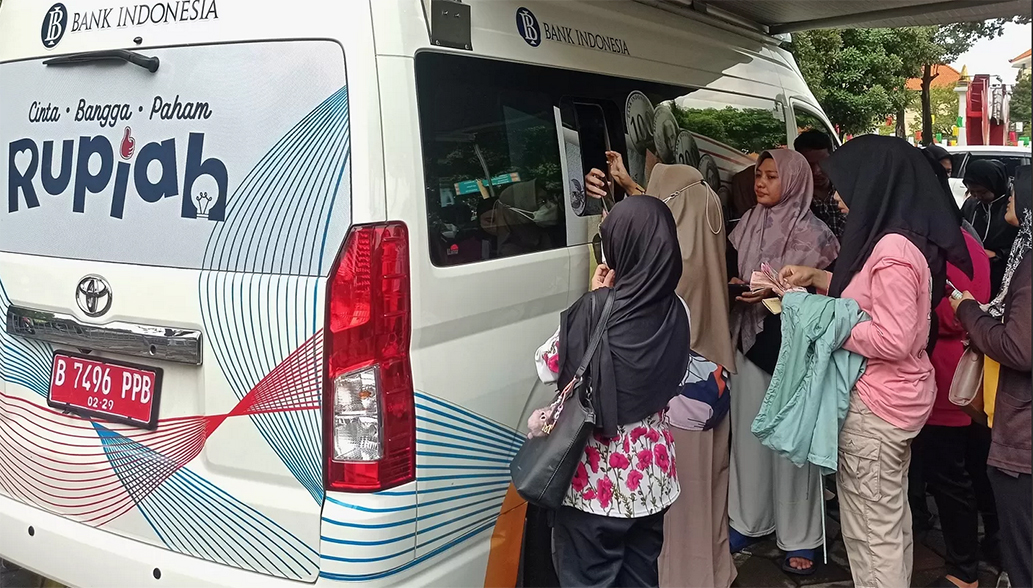 Warga Surabaya antre menukarkan uang baru di mobil kas keliling Bank Indonesia di halaman Masjid Al Akbar, Surabaya. (Suryanto/Radar Surabaya)