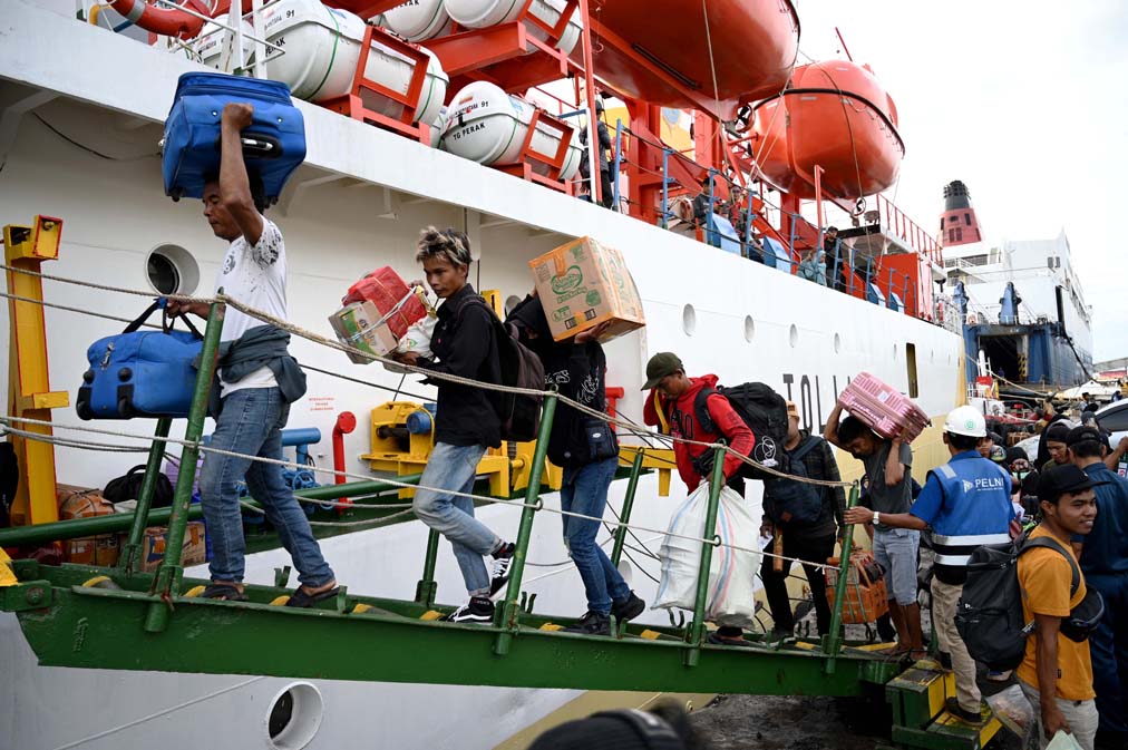 MUDIK LEBIH AWAL: Para penumpang kapal Sabuk Nusantara 91tujuan Pulau Sapeken naik ke geladak kapal sembari membawa barang bawaan, Rabu (19/3).