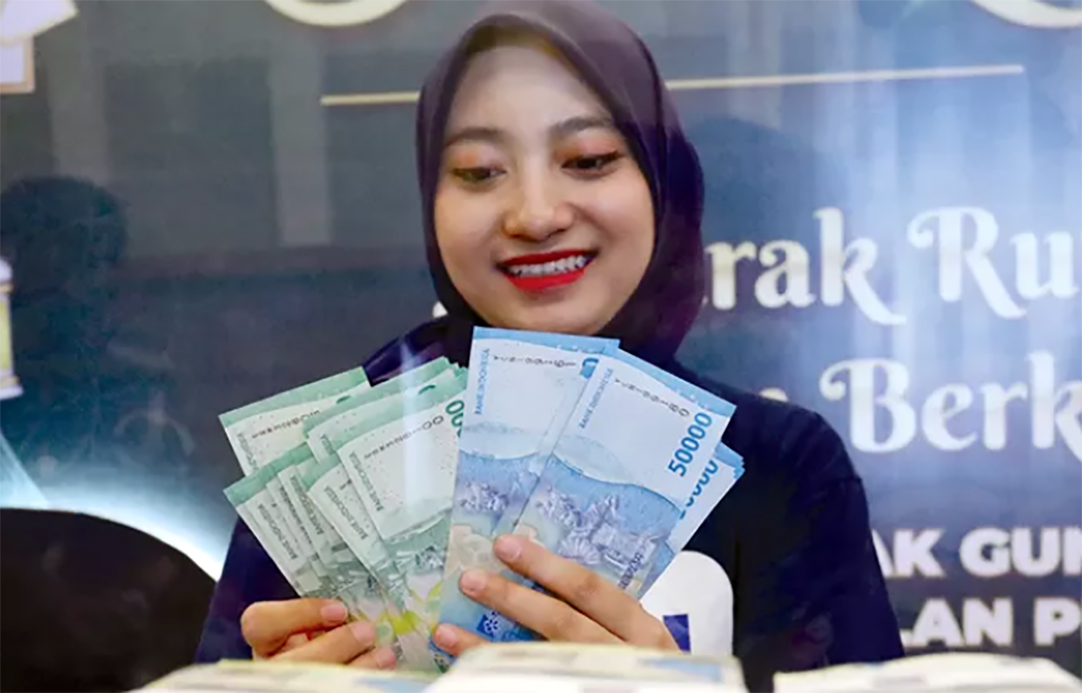 Seorang nasabah menukar uang baru di penukaran uang Serambi Bank Indonesia di pusat perbelanjaan. (Puguh Sujiatmiko/Jawa Pos)
