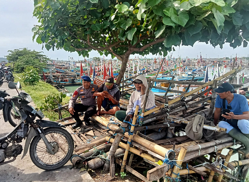 DIALOG: Kanit Polairud Unit Muncar, Bripka I Wayan Wedhana memberikan sosialisasi dan imbauan kepada nelayan terkait ombak besar dan cuaca ekstrem, Jumat (21/3).