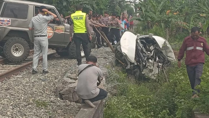 Petugas mengevakuasi mobil Daihatsu Sigra yang tertemper Kereta Api Batara Kresna di Sukoharjo, Rabu (26/3).