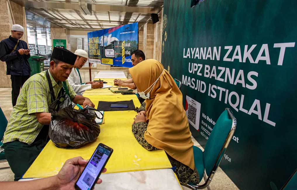 Amil melayani umat Islam yang membayar zakat fitrah di Masjid Istiqlal, Jakarta. (Foto: Miftahul Hayat/Jawa Pos)