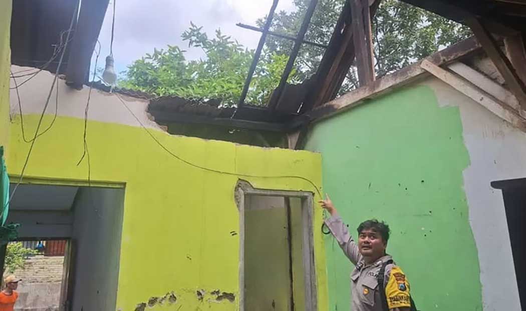 Petugas kepolisian menunjukkan bagian atap rumah milik Handayani, warga Dusun Cantuk Lor, Desa Cantuk, Kecamatan Singojuruh, usai dilanda kebakaran pada Rabu (2/4).
