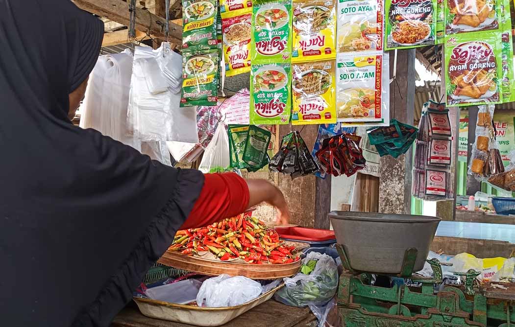 ANJLOK: Salah satu pedagang di Pasar Rakyat Desa/Kecamatan Sempu menata cabai rawit jualannya, Jumat (4/4).