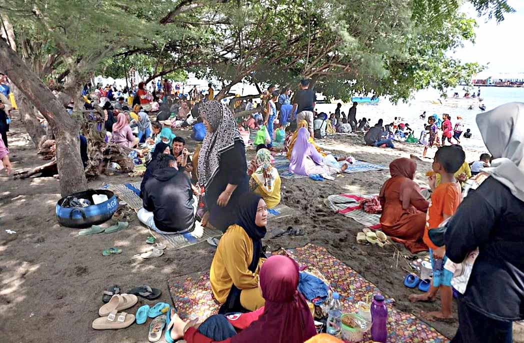 KETIBAN REJEKI: Jasa sewa tikar di destinasi wisata konservasi Bangsring Underwater laku keras, banyak keluarga bersantai di pasir pantai beralaskan tikar.