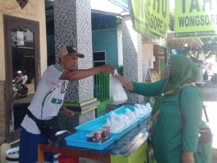 Mulyadi saat melayani pembeli tahu Wongsorejo, Sabtu (5/4).