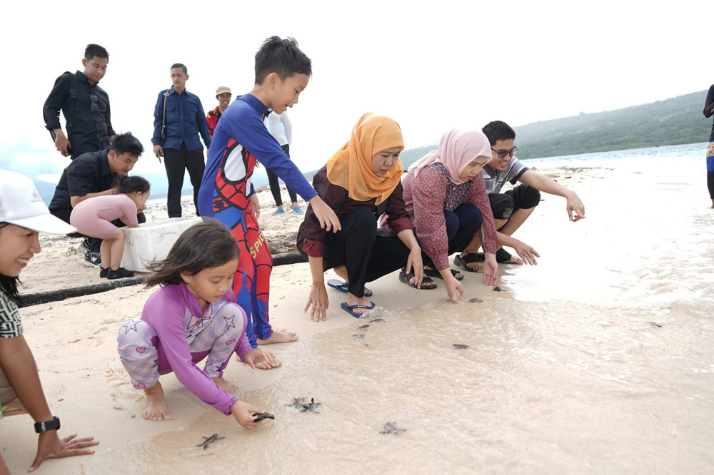 LESTARIKAN LINGKUNGAN: Gubernur Jatim Khofifah Indar Parawansa bersama keluarga melepas tukik di Pulau Tabuhan menjelang akhir pekan lalu (3/4).