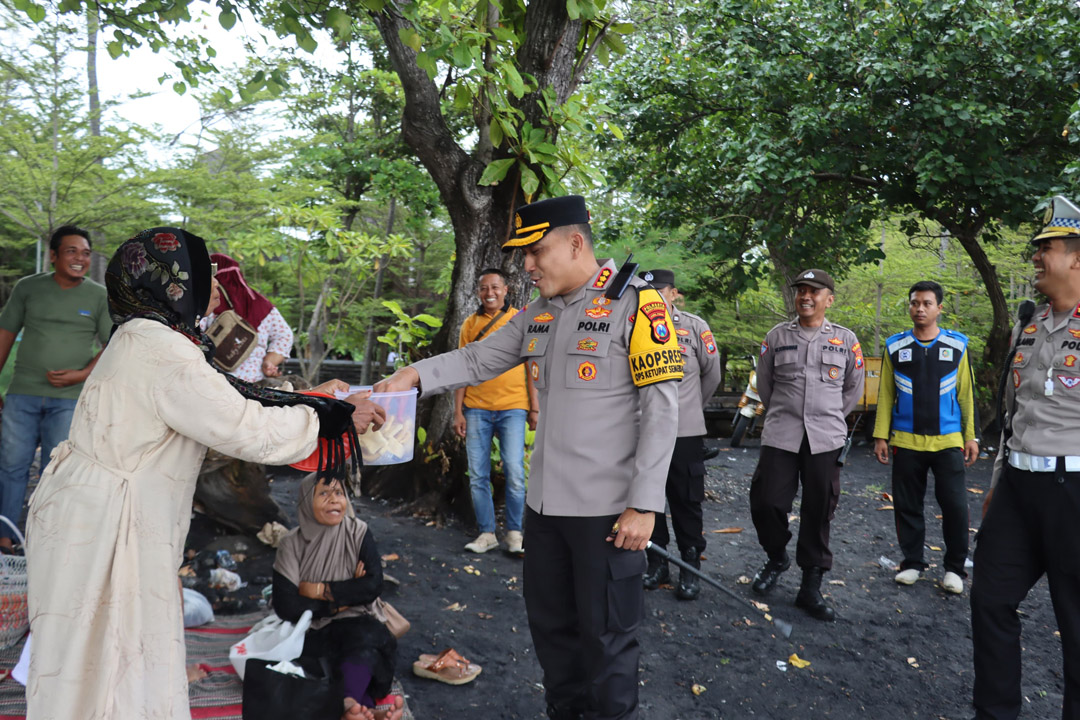 HUMANIS: Kapolresta Banyuwangi Kombespol Rama Samtama Putra mengambil camilan yang diberikan oleh salah satu pengunjung Pantai Cemara, Minggu (6/4).