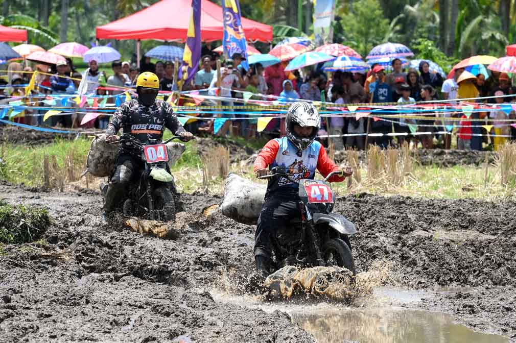 Peserta Manol Motocross beradu cepat dalam balapan di kawasan persawahan yang disulap menjadi sirkuit dadakan di Desa Parangharjo, Songgon, Selasa (8/4).
