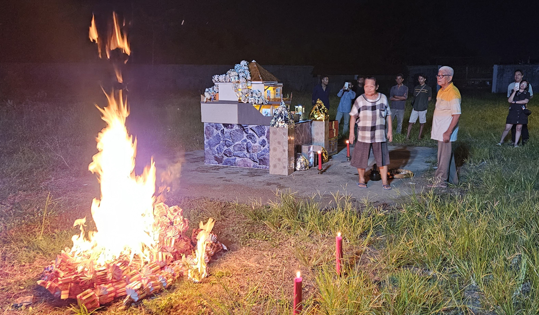 UNTUK ARWAH: Ritual bakar uang arwah digelar di Rumah Persemayaman Mitra Abadi, Minggu (13/4) malam.