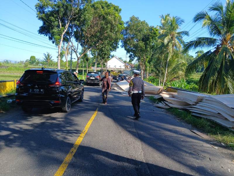 BUKA TUTUP: Anggota Unit Lantas Polsek Genteng mengatur arus lalu lintas lalin di jalan raya dekat TPU Dusun Wadung Dolah, Desa Kaligondo, Kecamatan Genteng Rabu (16/4).