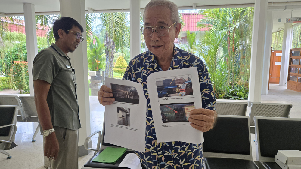 BUKTI: Untung Sugiarto menunjukkan foto bangunan yang diduga melanggar saat ditemui di DPRD Banyuwangi, Kamis (17/4).