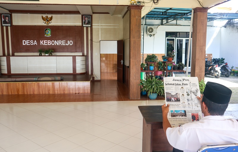 BERJALAN NORMAL: Perangkat Desa Kebonrejo, Kecamatan Kalibaru membaca koran di pendopo desa Rabu (23/4).