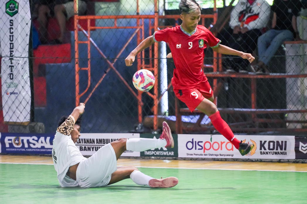 Pemain futsal Banyuwangi, Dedy Nirsa Pratama, menghindari tekling keras dari pemain Probolinggo Kota dalam laga pra-porprov di lapangan Scudeto Banyuwangi, Senin (28/4)