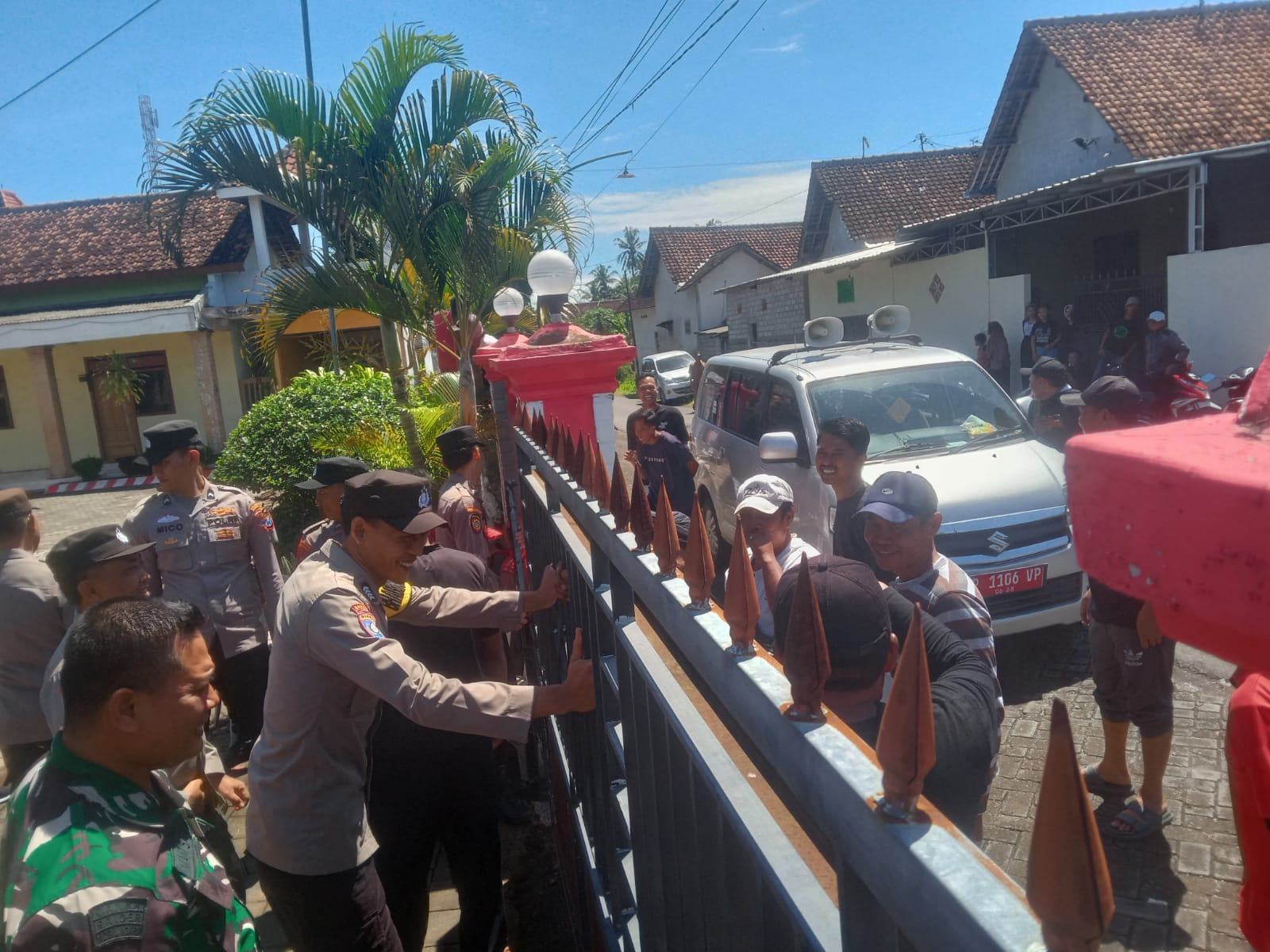 TAK BOLEH MASUK: Warga yang akan masuk kantor Desa Plampangrejo, Kecamatan Cluring dihadang di pintu gerbang oleh anggota polisi dan TNI Senin (28/4).