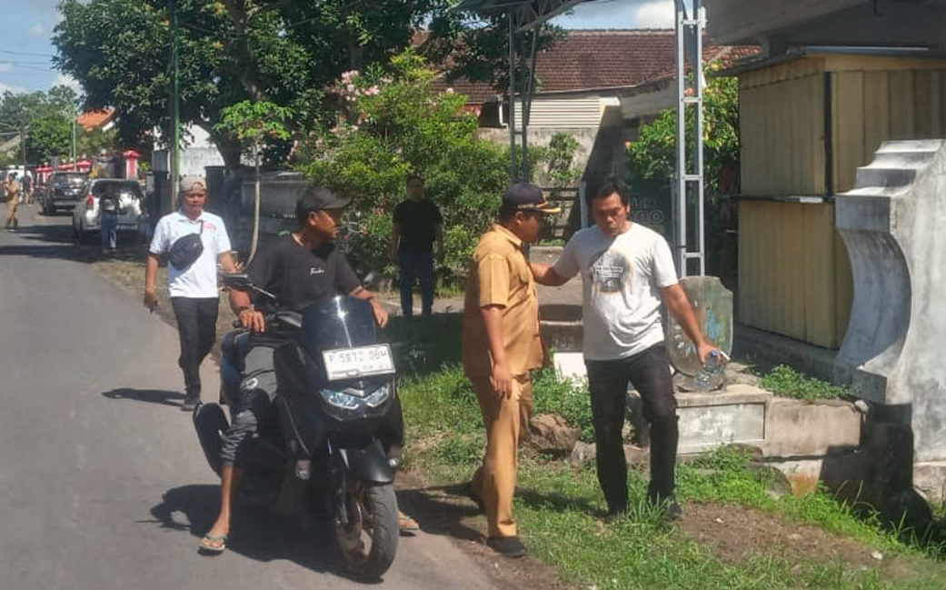 MUNDUR: Kades Yudi Wiyono (pakai kaus putih) pulang dengan jalan kaki dan menolak diantar staf desa setelah menyerahkan surat pengunduran diri dan baju dinas, Senin (28/4).