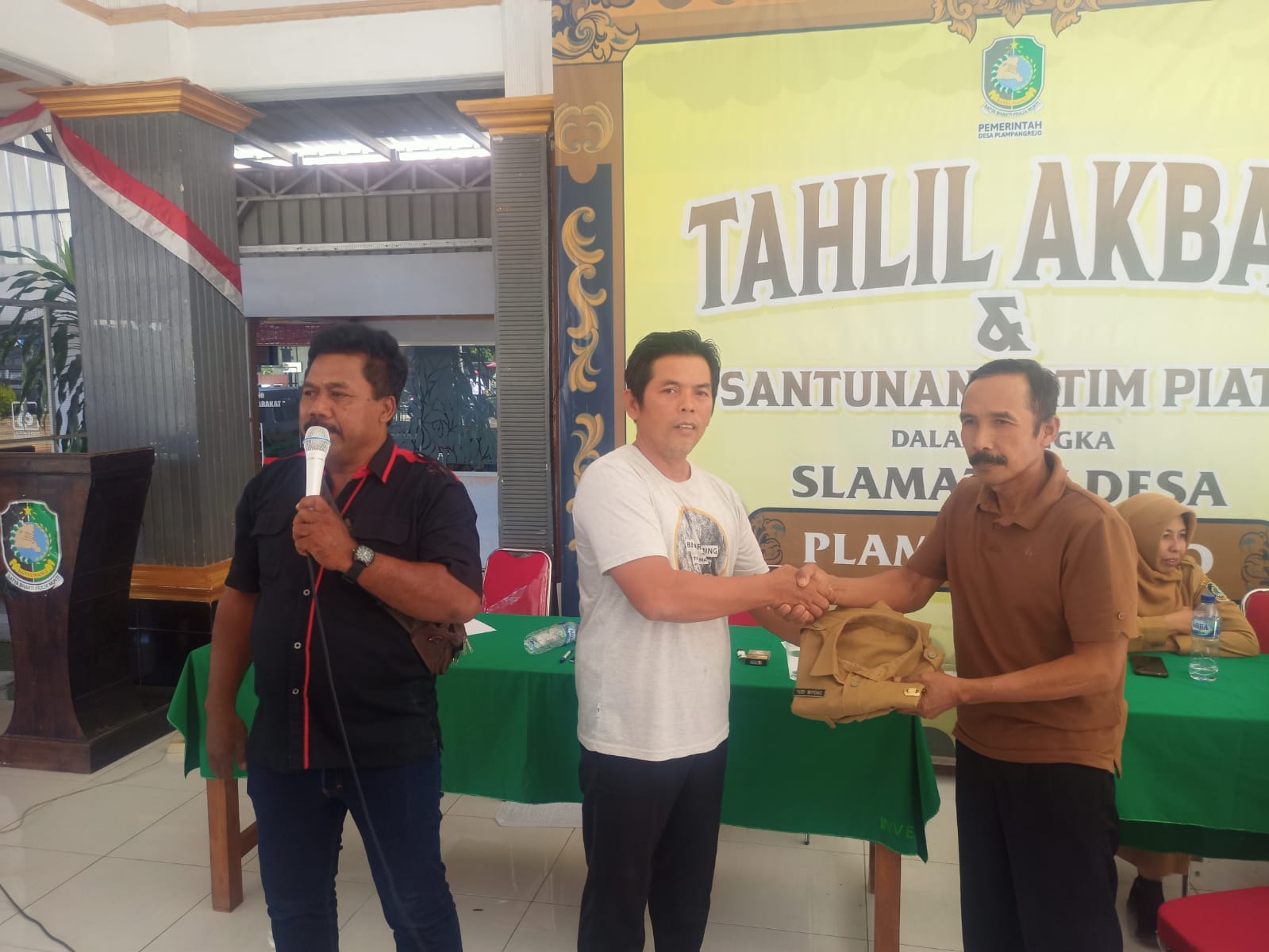 IKHLAS: Kades Yudi Wiyono menyerahkan pakaian dinasnya kepada Ketua BPD Plampangrejo Agus Sakiyar di balai desa setempat Senin (28/4).