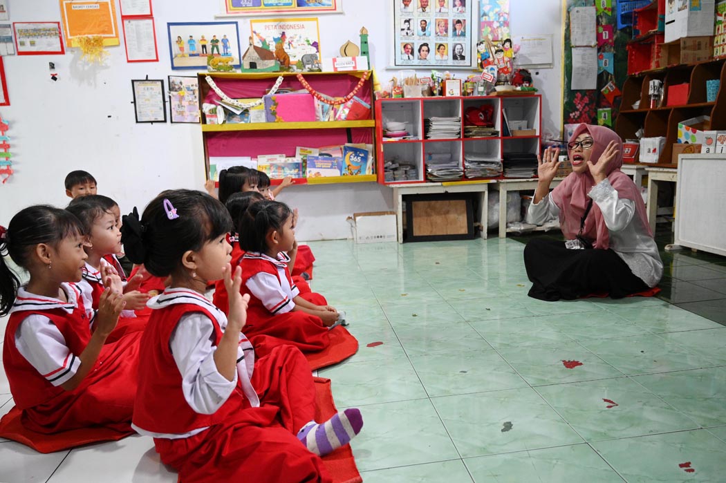 MENYENANGKAN: Guru TK Siwi Peni 2 memandu para siswa belajar sembari bermain di lembaga pendidikan yang berlokasi di Kelurahan Singonegaran, Banyuwangi, Selasa (6/5).