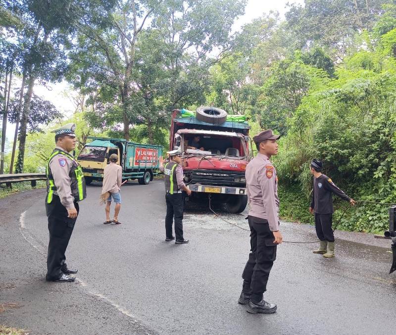 EVAKUASI: Anggota Unit Lantas Polsek Kalibaru dibantu relawan mengevakuasi truk yang tabrakan dengan bus di Jalur Gumitir, Dusun Barurejo, Desa Kalibaru Manis, Kecamatan Kalibaru Senin (6/5
