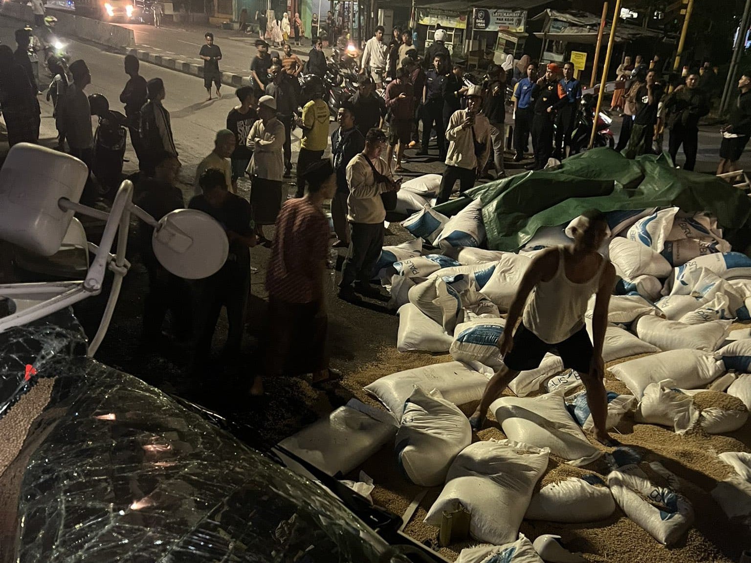 Warga berkerumun di sekitar karung kedelai yang berhamburan usai KA Harina tertemper truk di JPL 5, Kota Semarang, Jawa Tengah, Kamis (8/5) pagi.