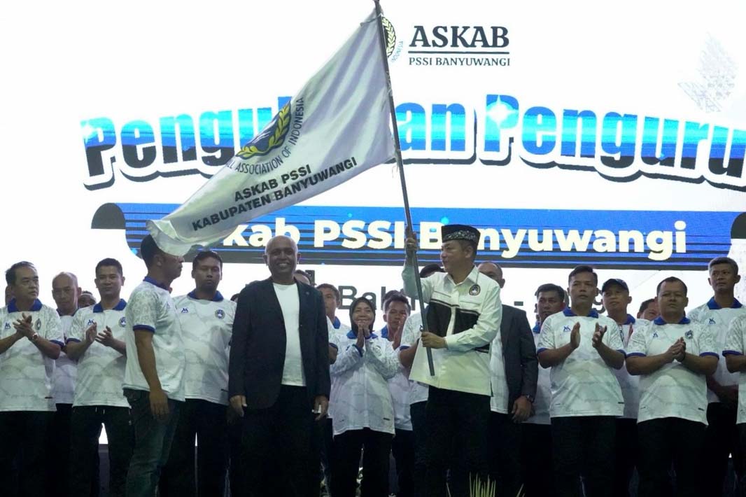 MULAI BEKERJA: Michael Edy Hariyanto mengibarkan bendera saat dilantik sebagai ketua Askab PSSI Banyuwangi di Alam Indah Lestari (AIL), Jumat malam (9/5).