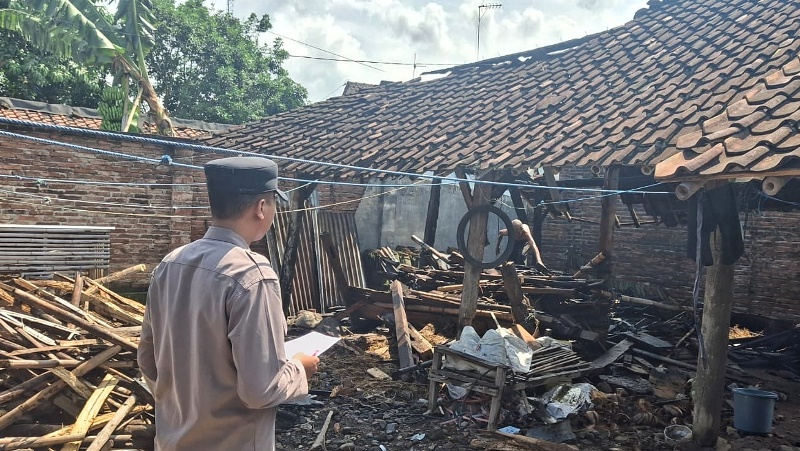 CEK: Anggota Polsek Genteng mengecek bekas kandang sapi milik Gimin di Dusun Krajan II, Desa Kembiritan, Kecamatan Genteng yang terbakar Senin siang (12/5)