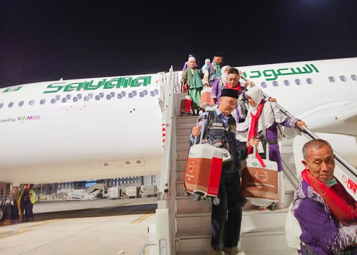 Petugas Haji Indonesia kloter 44 Banyuwangi Zainur Rofiq saat membantu jamaah membawakan tas koper. Mereka tiba di Madinah dini hari Kamis (15/5).