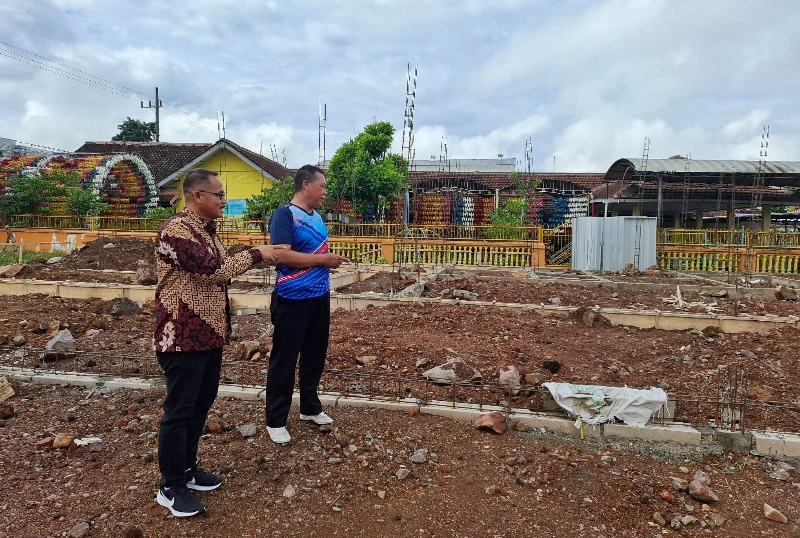 CEK: Camat Genteng Satrio (kiri) dan Korsda Genteng Sarwadi mengecek proyek yang mangkrak di depan Kantor Korsda Genteng di Desa Genteng Kulon, Kecamatan Genteng Rabu (14/5).