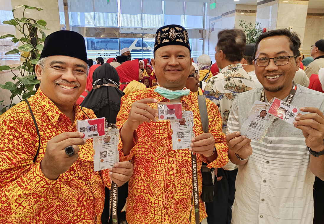 WAJIB DIMILIKI JEMAAH: Ketua Kafilah KBIHU Sabilillah Sudarsono (tengah) bersama jemaah lain menunjukkan kartu nusuk, Senin (19/5).