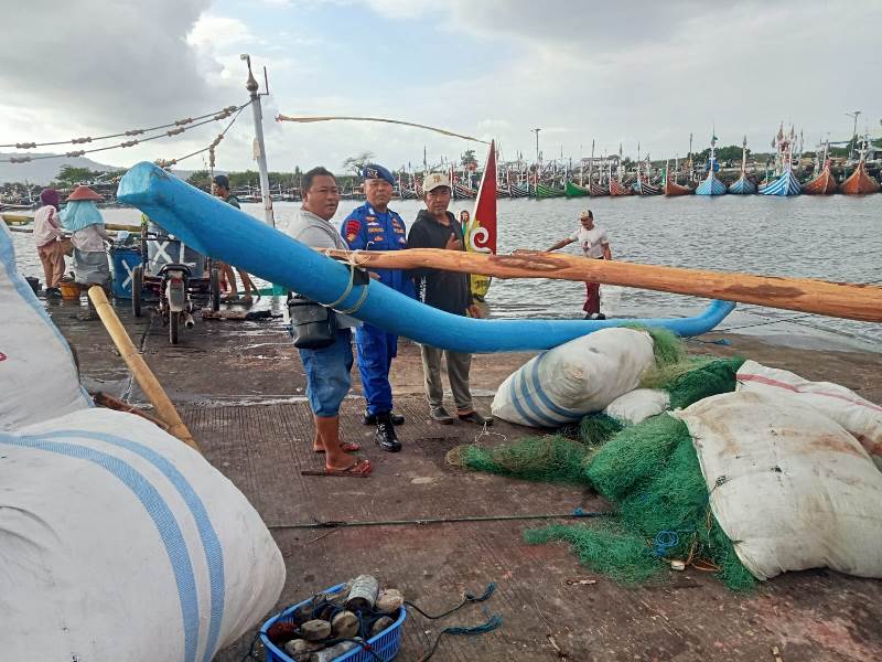 HIMBAUAN: Kanit Polairud Muncar Bripka I Wayan Wedhana menemui nelayan di Pelabuhan Muncar dan minta waspada karena cuaca buruk Selasa (20/5).