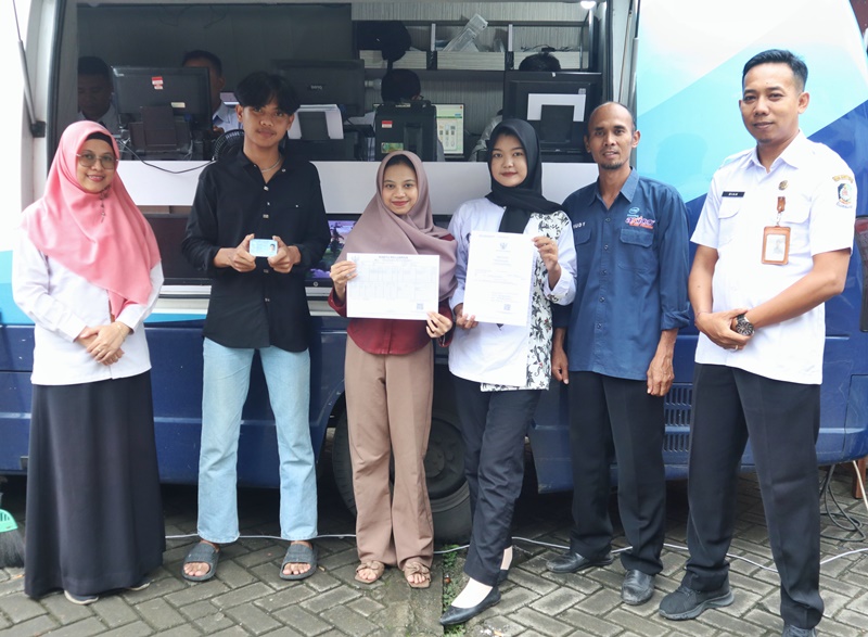 PROSES CEPAT: Tiga siswa SMK Muhammadiyah 8 Siliragung menerima data kependudukannya dari petugas Sispendukcapil Banyuwangi Rabu (21/5).