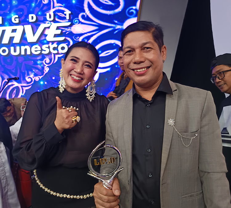 Husin Albana bersama artis dangdut, Eri Susan, saat menerima tropi juara Lomba Cipta Lagu Dangdut di Jakarta, Jumat (23/5).