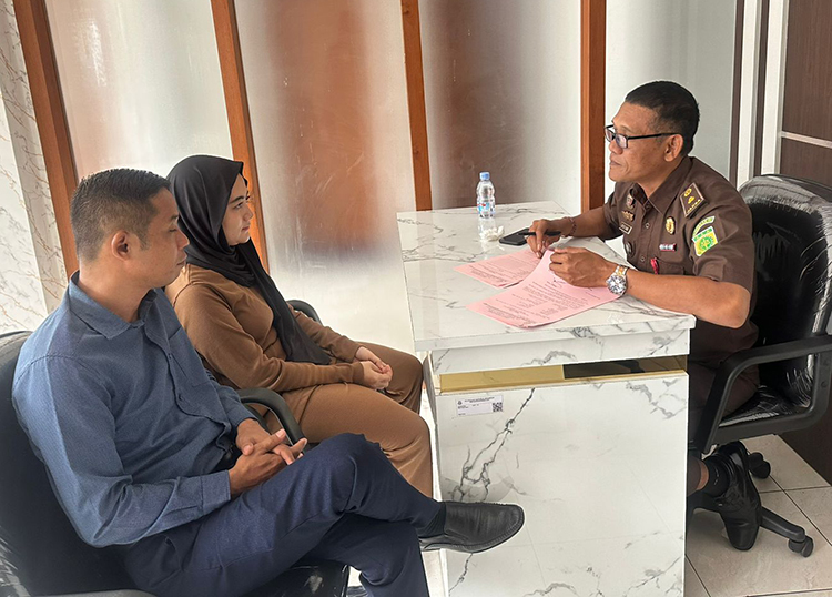 RS (pakai hijab) yang merupakan tersangka penggelapan didampingi kuasa hukumnya Eko Sutrisno saat menghadap JPU di Kejari Banyuwangi, Jumat (23/5).