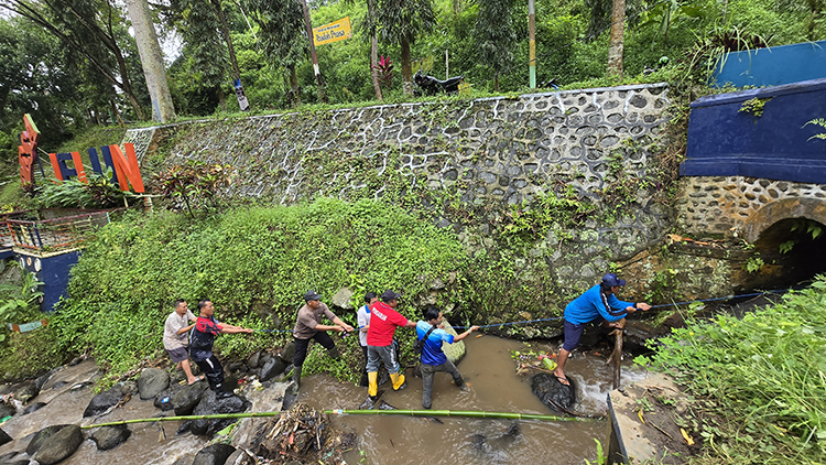 Sejumlah petugas Korsda Kabat membersihkan gorong-gorong yang tersumbat di Desa Jelun, Kecamatan Licin, Jumat (23/5).
