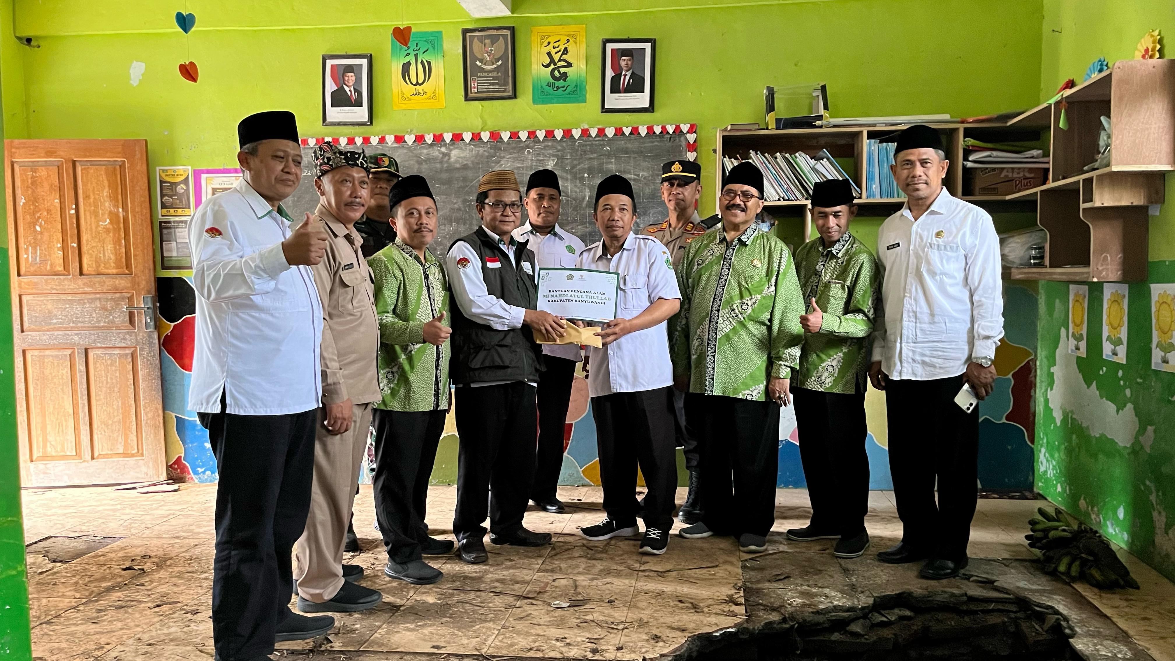 Kepala Kantor Kemenag Dr Chaironi Hidayat bersama pimpinan Baznas Banyuwangi menyerahkan bantuan kepada pihak MI Nahdlatul Thullab Segobang, Licin, Selasa (27/5).