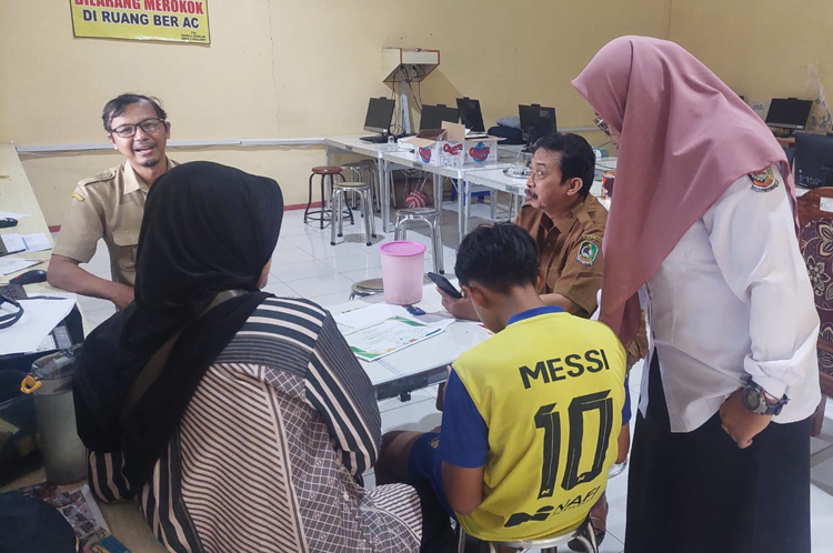 ANTUSIASME PESERTA: Panitia SPMB melayani peserta dan orang tua yang melakukan pendaftaran jalur prestasi di ruang di SMPN 2 Rogojampi, Selasa (27/5).