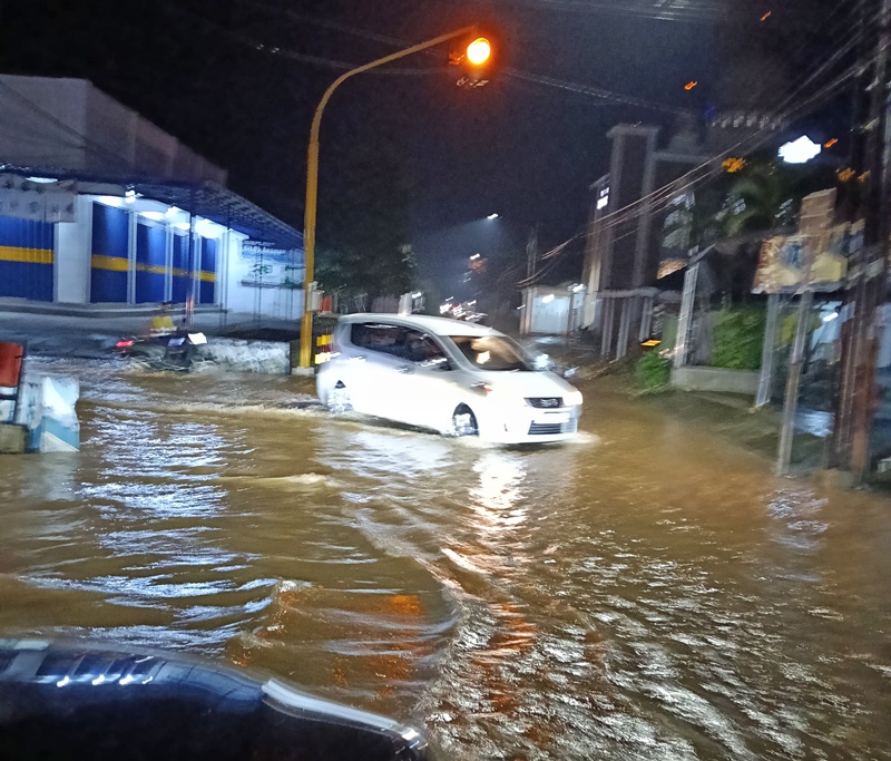 JADI KOLAM: Jalan Simpang Tigaa Lowi di barat kantor Desa Sumberagung, Kecamatan Pesanggaran selalu banjir setiap turun hujan deras pada Minggu (25/5) malam.