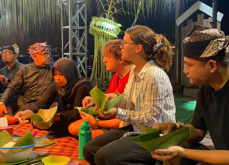 Rombongan wisatawan mancanegara ikut berbaur dengan warga lokal menyantap menu Tumpeng Sewu.